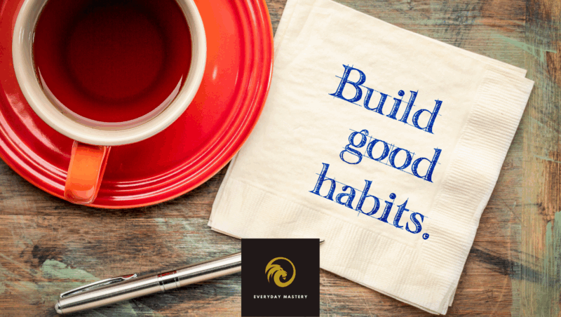 Coffee cup next to an open notebook with a page that says 'Build Good Habits', representing daily habit-building and personal growth