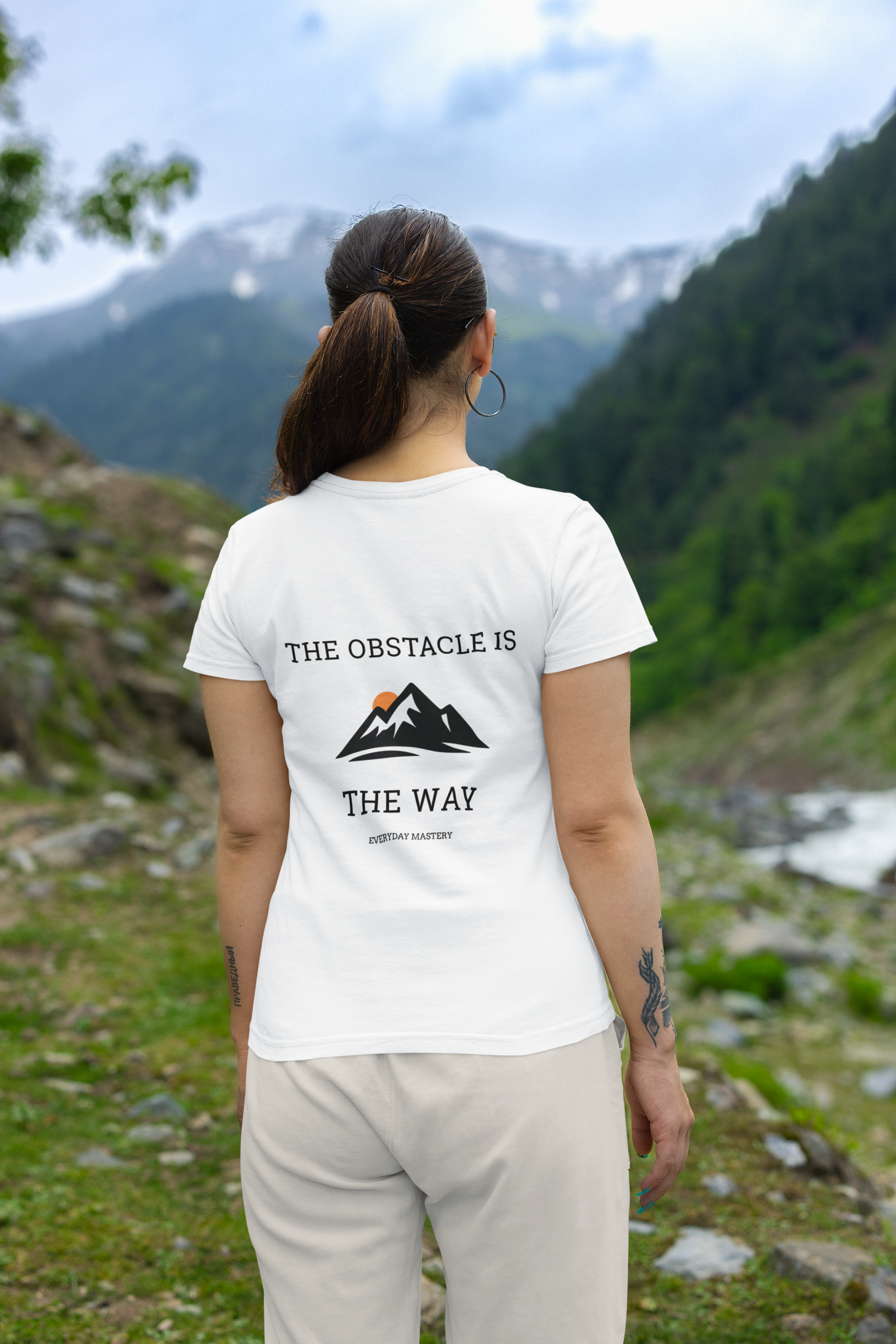 "Woman wearing Obstacle is the Way motivational t-shirt outdoors. Daily Mastery