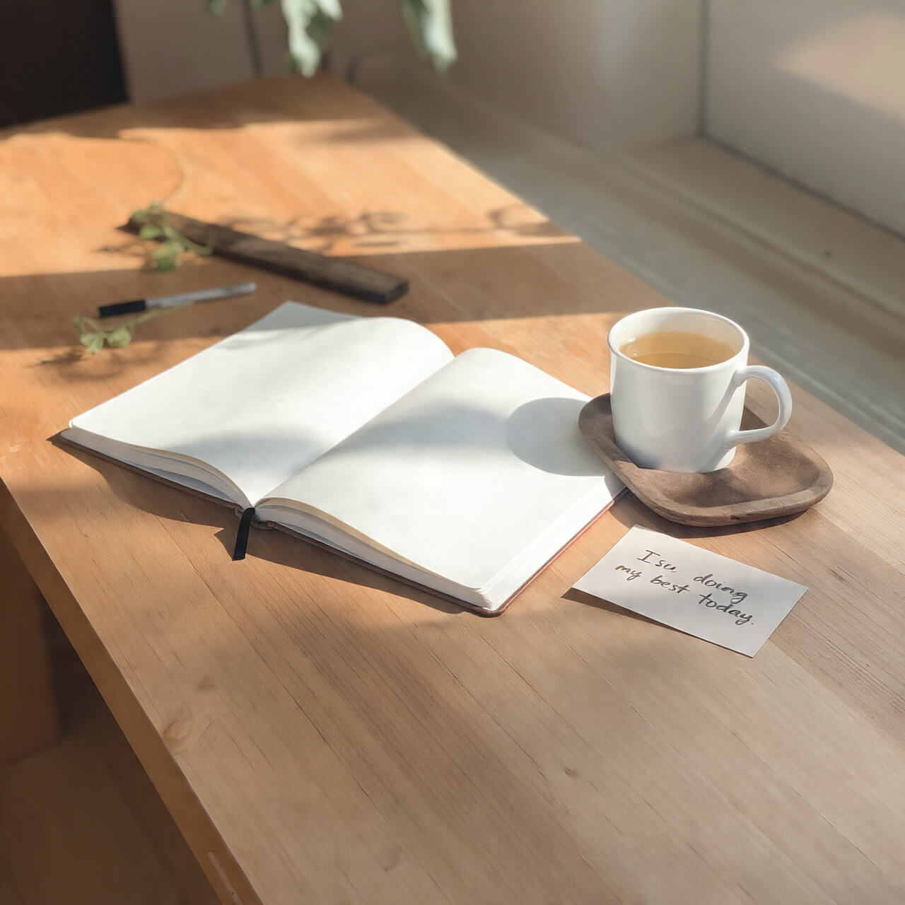 50 Practical Bridge Affirmations to Silence Your Inner Critic Open journal beside a cup of tea on a wooden desk, sunlight streaming through the window, symbolising calm reflection and everyday mastery through bridge affirmations.