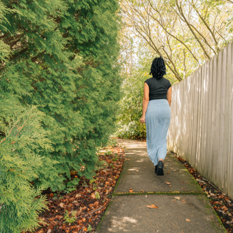 Woman walking alone on peaceful path showing how daily habits for self improvement create lasting change. Easy habits that work
