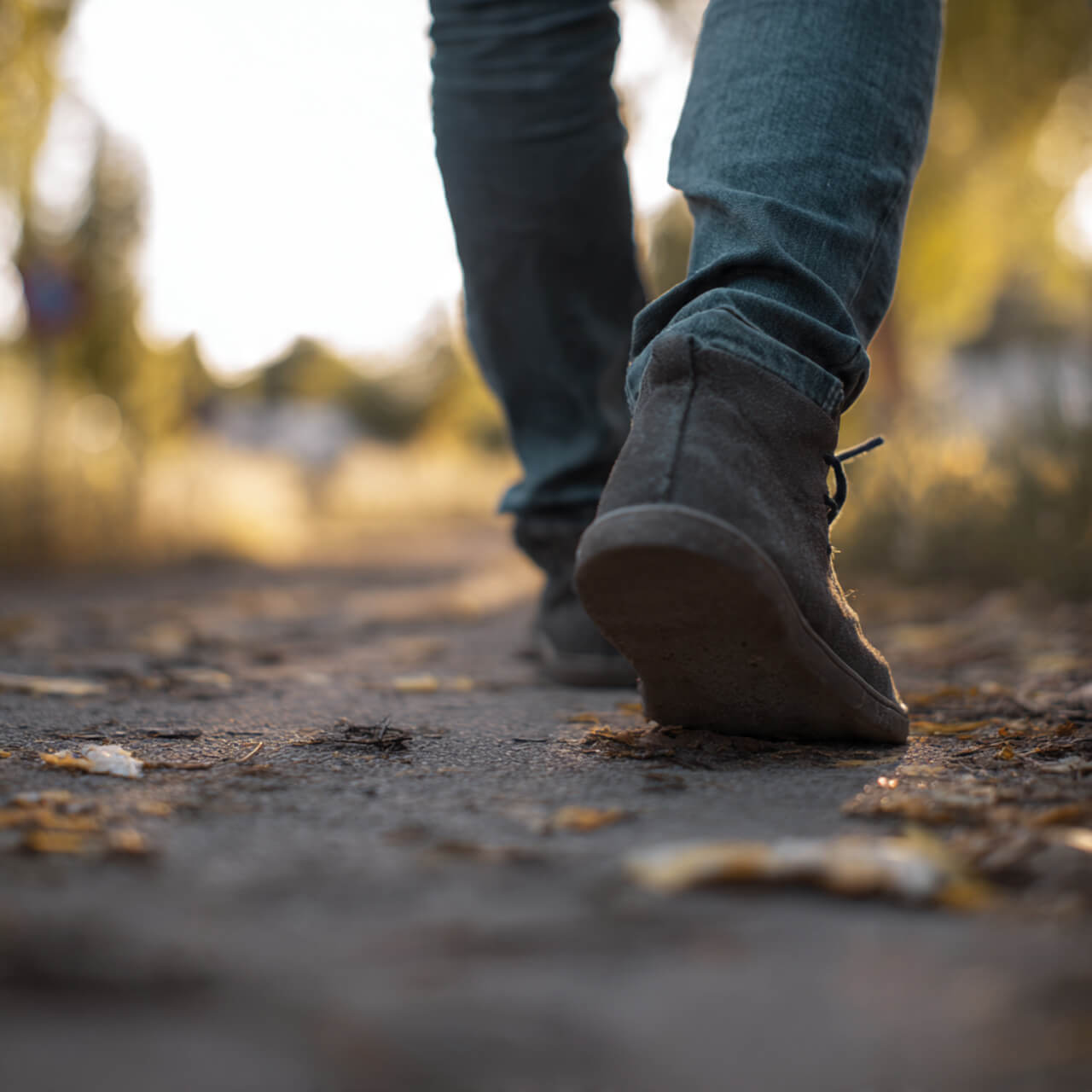 Close-up of feet walking mindfully on path - beginner walking meditation technique for restless minds