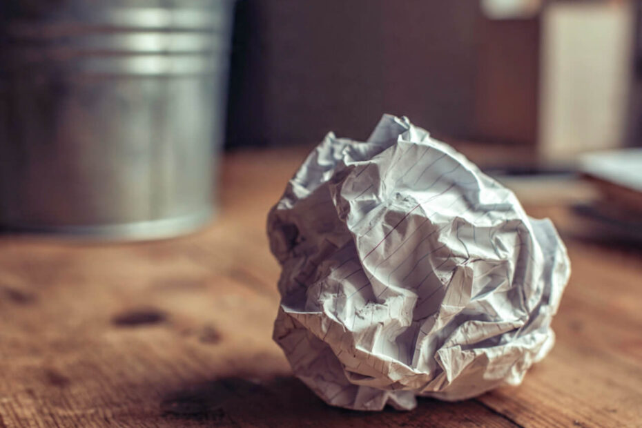 Crumpled paper list on a desk near a bin - why new year's resolutions fail by February