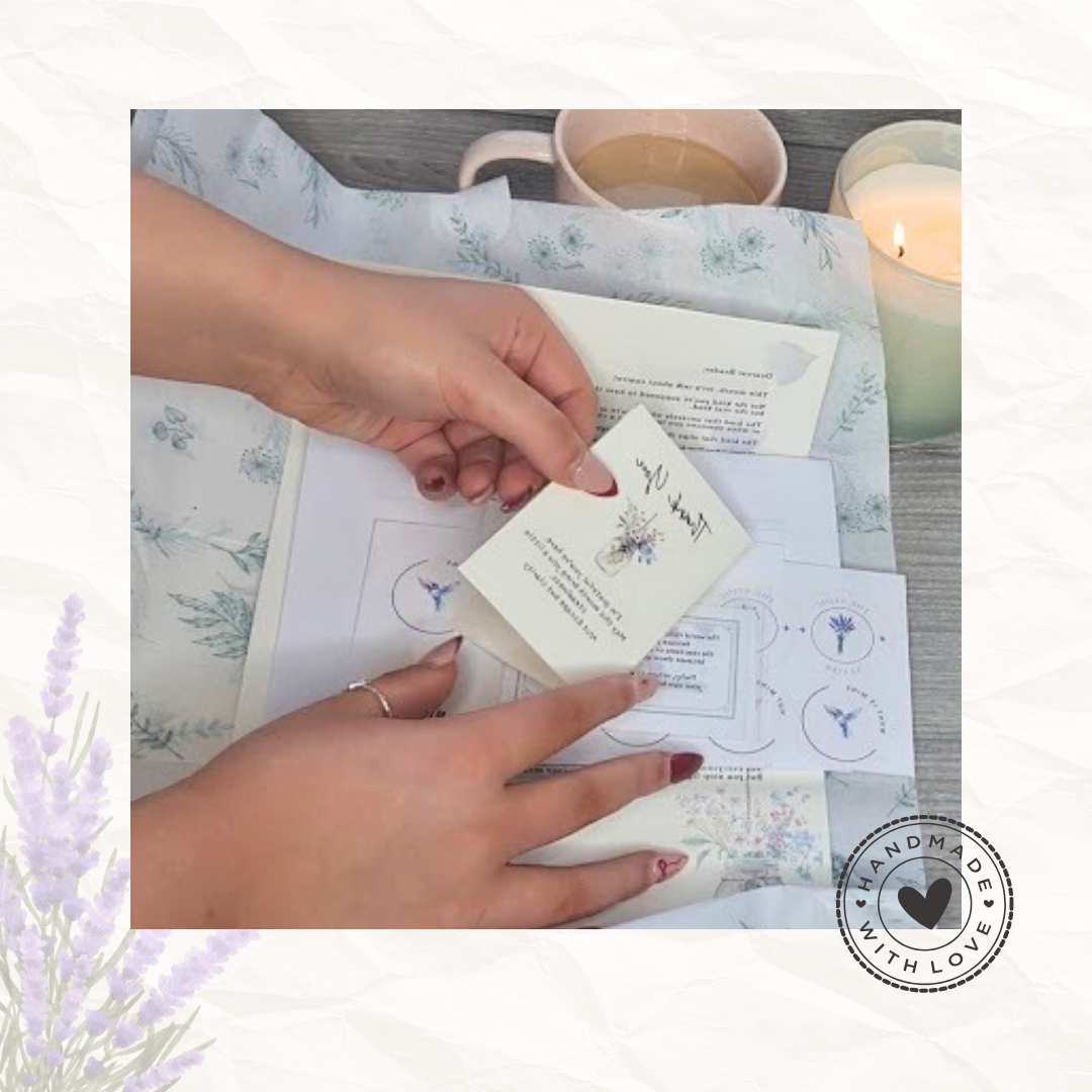 Hands unpacking The Stoic Letter monthly subscription contents including thank you card pocket tools and reflection sheets with candle and tea